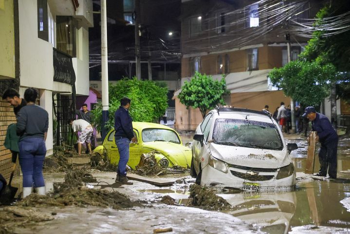 [아레키파=AP/뉴시스] 지난 19일(현지 시간) 페루 아레키파에서 폭우로 홍수가 발생한 뒤 주민들이 차량이 침수된 채 파손된 도로를 복구하고 있다. 사진은 기사와 직접적 관련 없음. 2026.02.24.