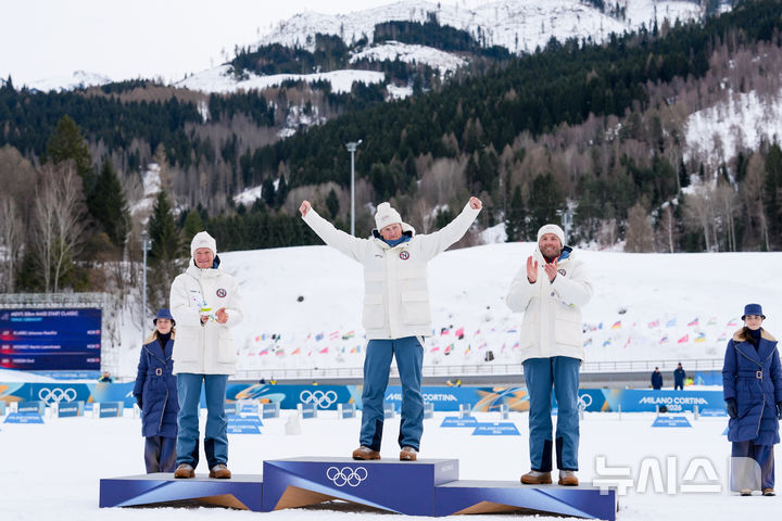 [테세로=AP/뉴시스] 요한네스 회스플로트 클레보(가운데)가 21일(한국 시간) 이탈리아 테세로 크로스컨트리 스타디움에서 열린 2026 밀라노·코르티나담페초 동계올림픽 크로스컨트리 스키 남자 50㎞ 매스스타트 클래식에서 우승을 차지한 뒤 시상대에 오르고 있다. 노르웨이 동료이자 은메달리스트 마르틴 뢰브스트룀 뉘엥에트(왼쪽), 동메달리스트 에밀 이베르센은 그에게 박수를 보내고 있다. 2026.02.21.