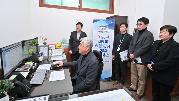 최승준(왼쪽) 정선군수가 군청 세무과에서 직원들이 지켜보는 가운데 2026년 성실(유공)납세자 추첨을 하고 있다.(사진=정선군 제공) *재판매 및 DB 금지