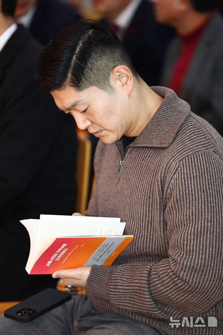 [서울=뉴시스] 김명년 기자 = 김재섭 국민의힘 의원이 22일 오후 서울 마포구 청년문화공간JU에서 열린 오세훈 서울시장 '시민의 자부심을 디자인하다' 출간기념회에서 책을 읽고 있다. 2026.02.22. kmn@newsis.com