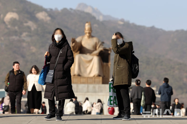 [서울=뉴시스] 조성우 기자 = 황사의 영향으로 서울에 미세먼지 경보가 발령된 22일 서울 종로구 광화문광장에서 마스크를 쓴 관광객들이 이동하고 있다. 2026.02.22. xconfind@newsis.com