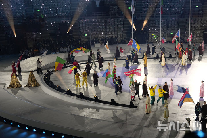 [베로나=AP/뉴시스] 23일(한국 시간) 이탈리아 베로나의 베로나 아레나에서 열린 2026 밀라노·코르티나담페초 동계올림픽 폐회식에 각국 국기가 등장하고 있다. 한국 선수단의 기수 최민정과 황대헌(사진 왼쪽)도 태극기를 함께 흔들며 경기장에 들어서고 있다. 2026.02.23.