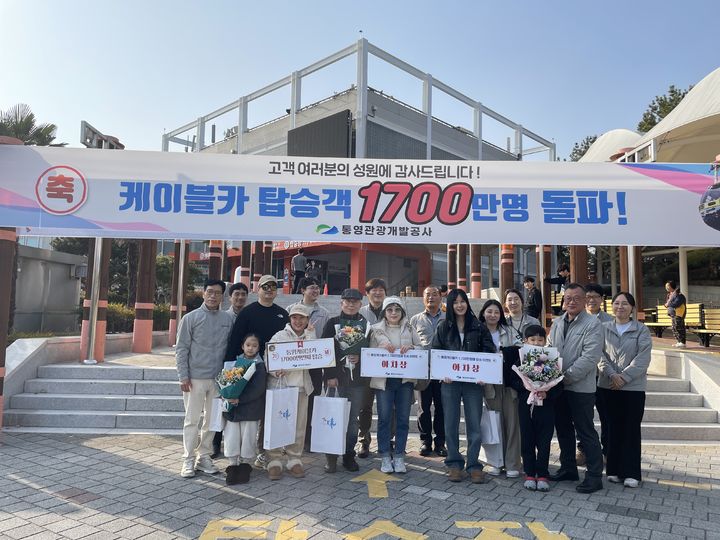 [통영=뉴시스] 통영관광개발공사가 운영하는 통영케이블카가 지난 22일 개통 18년만에 누적 탑승객 1700만명을 돌파했다. 누적 탑승객 1700만명 번째 행운을 차지한 탑승객과 아차상을 수상한 일행들이 통영케이블카 하부역사 앞에서 기념사진을 촬영하고 있다. (사진=통영관광개발공사 제공) 2026.02.23. photo@newsis.com *재판매 및 DB 금지