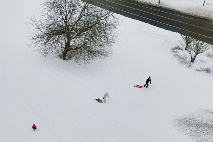 [뉴욕=AP/뉴시스] 23일(현지 시간) 미국 뉴욕 킹스 파크에서 어린이들이 썰매를 타기 위해 이동하고 있다. 미 북동부 지역에 폭설과 강풍을 동반한 겨울 폭풍으로 주요 도시 공항 운영이 중단되고 도로 교통이 마비됐다. 2026.02.24.