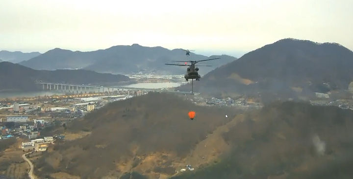 [밀양=뉴시스] 24일 오전 경남 밀양시 삼랑진읍 검세리 한 야산에서 발생한 산불현장에 투입된 군 시누쿠헬기가 산불 진화 작업을 하고 있다. (사진=산림청 동영상 캡처 제공) 2026.02.24. photo@newsis.com *재판매 및 DB 금지