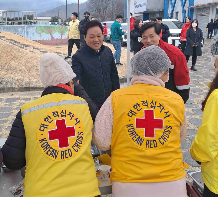 [창원=뉴시스]24일 박완수(왼쪽) 경남도지사가 대한적십자사 경남지사 봉사자들이 활동하고 있는 밀양 산불현장을 찾아 관계자들을 격려하고 있다. (사진=경남적십자사 제공) 2026.02.24.photo@newsis.com *재판매 및 DB 금지