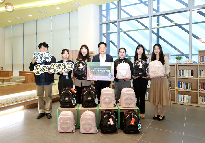 [울산=뉴시스] 24일 중구 우정혁신도시 한국동서발전 로비에서 권명호 사장과 직원들이 새학기 책가방 꾸러미를 들고 기념사진을 찍고 있다. (사진=한국동서발전 제공) 2026.02.24. photo@newsis.com *재판매 및 DB 금지