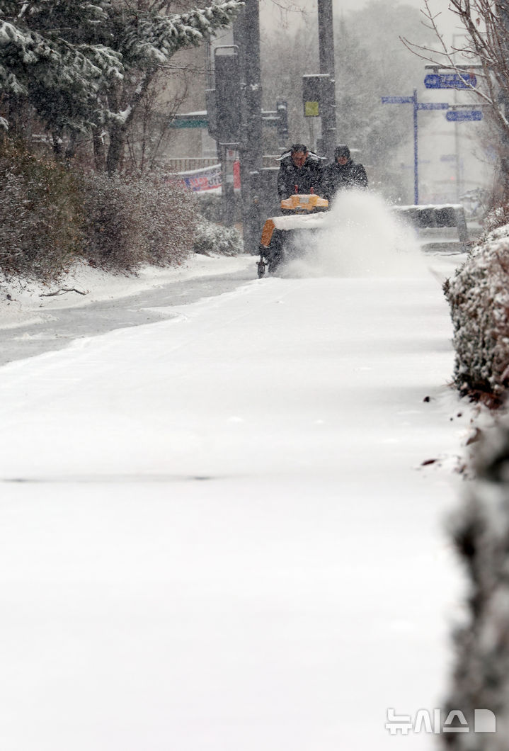 [세종=뉴시스] 강종민 기자 = 봄을 시샘하는 눈이 내린 24일 세종시 어진동에서 정부세종청사 관계자들이 인도의 눈을 치우고 있다.. 2026.02.24. ppkjm@newsis.com