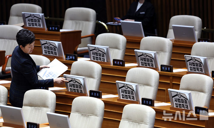 [서울=뉴시스] 김금보 기자 = 김은혜 국민의힘 원내 정책수석부대표가24일 오후 서울 여의도 국회에서 열린 제432회국회(임시회) 제 8차 본회의에서 국민의힘 의원 자리에 '사법파괴 입법독재'라 쓰여진 피켓을 부착하고 있다. 2026.02.24. kgb@newsis.com