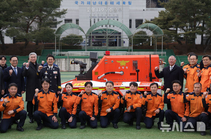 [남양주=뉴시스] 홍효식 기자 = 정의선 현대자동차그룹 회장과 김승룡 소방청장 직무대행을 비롯한 참석자들이 지난 24일(어제) 오후 경기도 남양주시 수도권119특수구조대에서 열린 현대자동차그룹-소방청 무인소방로봇 기증식에서 시연을 마친 뒤 기념촬영하고 있다. 2026.02.25. yesphoto@newsis.com