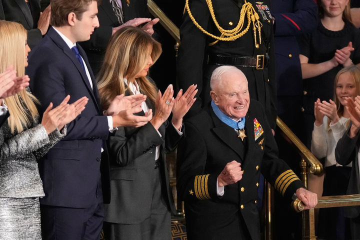 [워싱턴=AP/뉴시스] 24일(현지 시간) 미국 워싱턴DC 연방의회 의사당 하원 본회의장에서 도널드 트럼프 대통령이 국정연설을 하는 가운데, 멜라니아 여사가 앨머 로이스 윌리엄스에게 명예훈장을 수여한 뒤 윌리엄스가 손짓하고 있다. 2026.02.24.