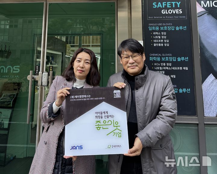 [창원=뉴시스]굿네이버스 권정은(왼쪽) 경남사업본부장이 25일 ㈜제이엠앤에스를 방문해 김성철 대표이사에게 '좋은이웃기업 현판'을 전달하고 있다.(사진=굿네이버스 경남사업본부 제공) 2026.02.25. photo@newsis.com