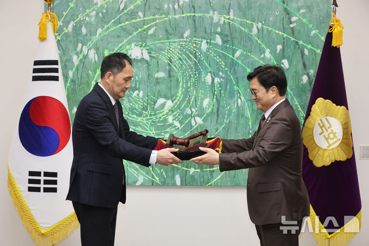 [서울=뉴시스] 김금보 기자 = 우원식 국회의장이 25일 서울 여의도 국회에서 열린 국회기록원 제1호 기록물 기증식에서 12·3 비상계엄 해제와 윤석열 전 대통령 탄핵소추안을 의결할 당시 사용하다 파손된 의사봉과 의사봉판을 곽건홍 국회기록원장에게 전달하고 있다. 2026.02.25. kgb@newsis.com