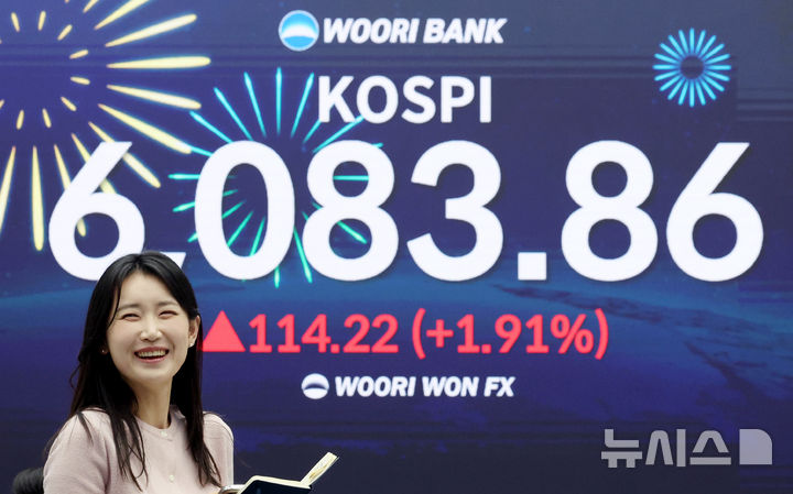 [서울=뉴시스] 김진아 기자 = 코스피가 사상 첫 6000을 돌파한 25일 서울 중구 우리은행 딜링룸에서 직원들이 축하 세리머니를 하고 있다. 25일 코스피는 전 거래일(5969.64)보다 114.22포인트(1.91%) 오른 6083.86에, 코스닥 지수는 전 거래일(1165.00)보다 0.25포인트(0.02%) 상승한 1165.25에 거래를 마쳤다. 2026.02.25. bluesoda@newsis.com