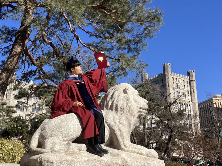 [서울=뉴시스] 김수빈 인턴기자 = 25일 오후 경희대 서울캠퍼스 전기 학위수여식에서 경희대 19학번 김모(26·남)씨가 사자상 위에 앉아 사진을 찍고 있다. 2026.02.25. *재판매 및 DB 금지