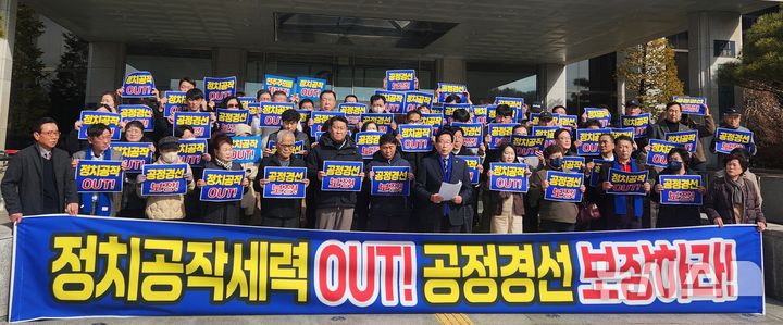 [충주=뉴시스] 이병찬 기자 = 더불어민주당 우건도(가운데) 전 충주시장과 지지자들이 26일 충북 충주시청에서 충북도당의 후보적격 정밀심사 결정을 "정치공작"이라고 비판하고 있다.2026.02.26.bclee@newsis.com 