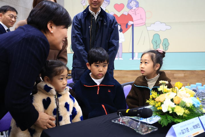 [세종=뉴시스]송미령 농림축산식품부 장관이 26일 장수군에서 제1호 농어촌 기본소득 수령자에게 지역사랑상품권을 직접 전달하고 지역 어린이들과 대화하고 있다. (사진=농식품부 제공) *재판매 및 DB 금지