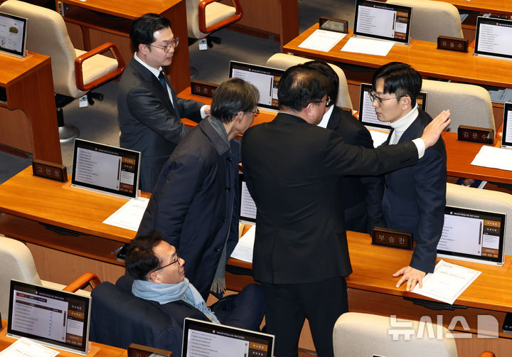 [서울=뉴시스] 김금보 기자 = 박충권 국민의힘 의원이 26일 서울 여의도 국회에서 열린 제432회 국회(임시회) 제8차 본회의에서 비속어를 사용한 박선원 더불어민주당 의원에게 항의하고 있다. 더불어민주당 의원들이 이를 제지하고 있다. 2026.02.26. kgb@newsis.com