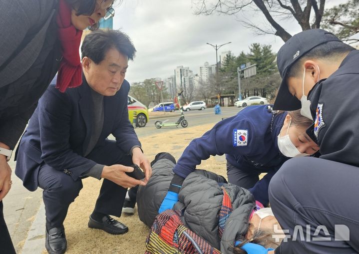 [군포=뉴시스] 하은호 시장(사진 왼쪽)이 공원 한쪽에 쓰러진 할머니를 걱정 스러운 표정으로 119구조대와 상태를 살피고 있다. (사진=군포시 제공).*재판매 및 DB 금지