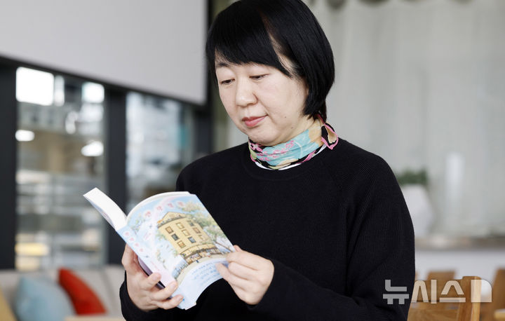 [인천=뉴시스] 김혜진 기자 = 조경아 작가가 지난달 27일 인천 중구 카페 마숑에서 뉴시스와 인터뷰에 앞서 책을 보고 있다. 2026.03.01. jini@newsis.com