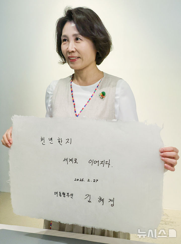 [전주=뉴시스] 최동준 기자 = 김혜경 여사가 27일 전북 전주천년한지관을 방문해 직접 제작한 한지를 들어 보이고 있다. (청와대통신사진기자단) 2026.02.27. photocdj@newsis.com