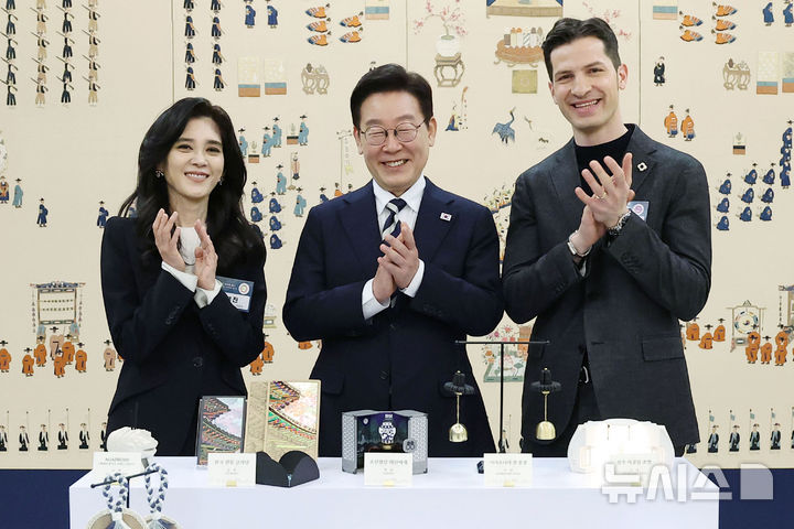 [서울=뉴시스] 최동준 기자 = 이재명 대통령이 25일 청와대에서 열린 '확대 국가관광전략회의'에서 이부진 한국방문의해위원장, 알베르토 몬디 주한이탈리아상공회의소 부회장과 대한민국 관광공모전 기념품 부문 수상작 앞에서 기념촬영을 하고 있다. (청와대통신사진기자단) 2026.02.25. photocdj@newsis.com