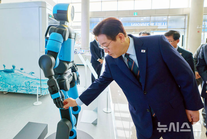 [서울=뉴시스] 최동준 기자 = 이재명 대통령이 27일 전북 군산 새만금컨벤션센터에서 열린 '새만금 로봇·수소·AI시티 투자협약식'에서 휴머노이드 로봇 아틀라스를 살펴보고 있다. (사진=청와대 제공) 2026.02.27. photo@newsis.com *재판매 및 DB 금지