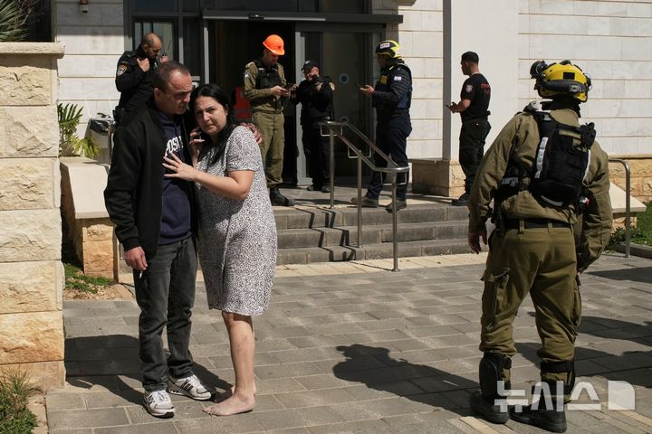 [하이파=AP/뉴시스] 정병혁 기자 = 미국이 이란에 대해 군사공격을 강행한 가운데 28일 이스라엘 북부 하이파 인근 티라트 하카르멜에서 주민들이 발사체를 맞은 건물에서 대피하고 있다. 2026.02.28. 