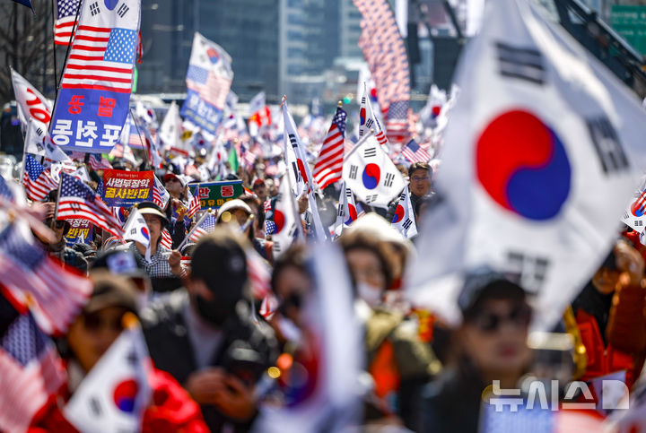 [서울=뉴시스] 정병혁 기자 = 28일 서울 종로구 세종대로에서 열린 자유통일을 위한 광화문 국민대회에서 참가자들이 태극기와 성조기를 들고 있다. 2026.02.28. jhope@newsis.com