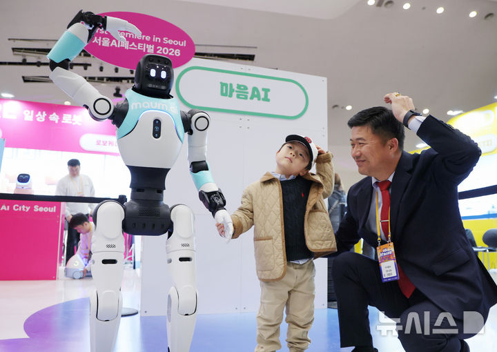 [서울=뉴시스] 김진아 기자 = 28일 서울 중구 동대문디자인플라자(DDP) 아트홀에서 열린 '서울AI페스티벌 2026'에서 아이들이 국내 최초로 일반에 공개되는 완전 자율형 민첩 로봇 '우치봇'과 머리 위로 하트 모양을 만들고 있다. 이번 행사 주제는 '인공지능(A)이 내게 말을 걸었다 - 몸으로 느끼는 일상 속 Physical AI'다. 인공 지능이 소프트웨어를 넘어 로봇·디바이스·웨어러블 등 실체를 가진 '피지컬 AI(Physical AI)' 기술로 구현되는 모습을 직접 체험할 수 있다. 2026.02.28. bluesoda@newsis.com
