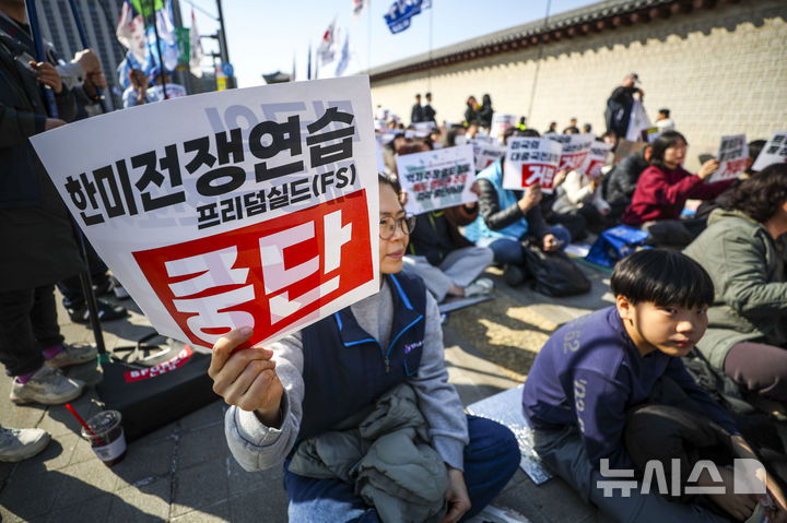 [서울=뉴시스] 정병혁 기자 = 28일 서울 종로구 동십자각 앞에서 열린 '한미전쟁연습 중단! 트럼프 통상압박 안보위협 거부! 시민행진'에서 참가자들이 피켓을 들고 있다. 2026.02.28. jhope@newsis.com