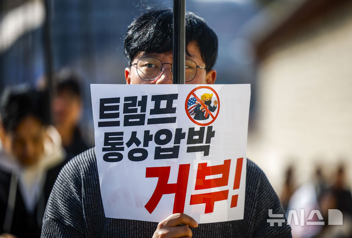 [서울=뉴시스] 정병혁 기자 = 28일 서울 종로구 동십자각 앞에서 열린 '한미전쟁연습 중단! 트럼프 통상압박 안보위협 거부! 시민행진'에서 참가자들이 피켓을 들고 있다. 2026.02.28. jhope@newsis.com