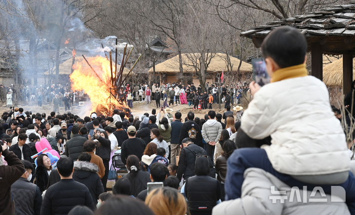 [용인=뉴시스] 김종택 기자 = 정월대보름을 이틀 앞둔 1일 경기 용인시 한국민속촌에서 열린 달집태우기 행사에서 시민들이 활활 타오르는 달집을 바라보며 풍요와 무사안녕을 기원하고 있다. 2026.03.01. jtk@newsis.com