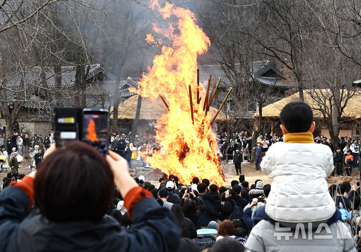 [용인=뉴시스] 김종택 기자 = 정월대보름을 이틀 앞둔 1일 경기 용인시 한국민속촌에서 열린 달집태우기 행사에서 시민들이 활활 타오르는 달집을 바라보며 풍요와 무사안녕을 기원하고 있다. 2026.03.01. jtk@newsis.com