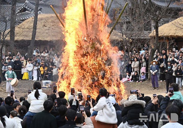[용인=뉴시스] 김종택 기자 = 정월대보름을 이틀 앞둔 1일 경기 용인시 한국민속촌에서 열린 달집태우기 행사에서 시민들이 활활 타오르는 달집을 바라보며 풍요와 무사안녕을 기원하고 있다. 2026.03.01. jtk@newsis.com