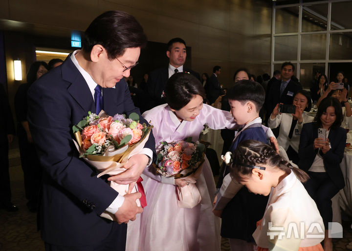 [싱가포르=뉴시스] 최동준 기자 = 싱가포르를 국빈 방문 중인 이재명 대통령과 김혜경 여사가 1일(현지 시간) 싱가포르 한 호텔에서 열린 동포 만찬 간담회에서 화동에게 꽃다발을 받고 있다. 2026.03.01. photocdj@newsis.com