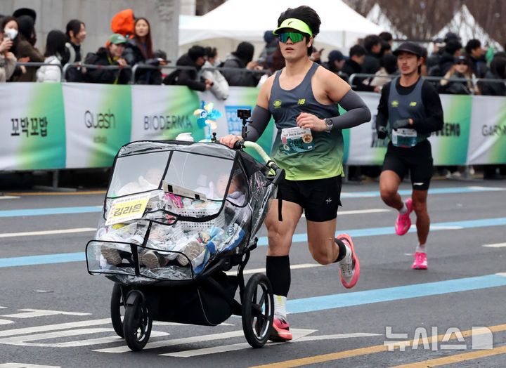 [서울=뉴시스] 추상철 기자 = 2일 오전 서울 종로구 광화문광장 앞에서 열린 '2026 서울 하프 레이스'에서 유모차에 아이를 태운 러너가 힘찬 출발을 하고 있다. 2026.03.02. scchoo@newsis.com