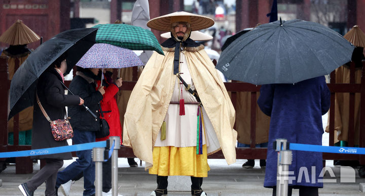 [서울=뉴시스] 추상철 기자 = 강풍을 동반한 비가 내린 2일 오전 서울 종로구 경복궁에서 수문장이 조선시대 우비인 유삼과 쓰개를 착용하고 있다. 2026.03.02. scchoo@newsis.com