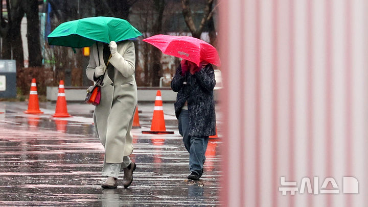 [서울=뉴시스] 추상철 기자 = 강풍을 동반한 비가 내린 2일 오전 서울 종로구 광화문광장에서 외국인 관광객이 우산을 쓰고 발걸음을 재촉하고 있다. 2026.03.02. scchoo@newsis.com