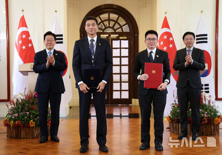 [싱가포르=뉴시스] 최동준 기자 = 홍진욱 주 싱가포르 대한민국대사와 웡 캉 젯 국립환경 청장이 2일(현지 시간) 싱가포르 외교부에서 이재명 대통령과 로렌스 웡 총리가 임석한 가운데 환경위성 공동활용을 위한 양해각서(갱신)를 들고 기념촬영을 하고 있다. 2026.03.02. photocdj@newsis.com