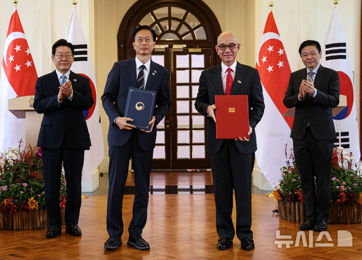 [싱가포르=뉴시스] 최동준 기자 = 김용선 지식재산처 처장과 니키 탄 지식재산청 이사회 의장이 2일(현지 시간) 싱가포르 외교부에서 이재명 대통령과 로렌스 웡 총리가 임석한 가운데 지식재산 분야 강화 협력 양해각서를 들고 기념촬영을 하고 있다. 2026.03.02. photocdj@newsis.com