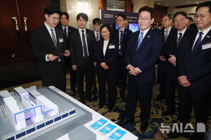 [싱가포르=뉴시스] 최동준 기자 = 싱가포르를 국빈 방문 중인 이재명 대통령이 2일(현지 시간) 한 호텔에서 열린 한-싱 AI 커넥트 서밋을 마친 뒤 전시 업체의 설명을 듣고 있다. 2026.03.02. photocdj@newsis.com