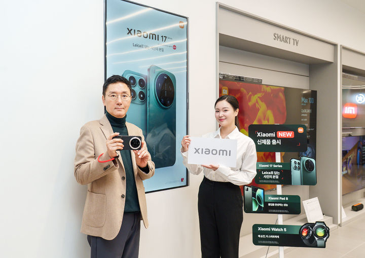 [서울=뉴시스] 샤오미코리아는 3일부터 5일까지 샤오미 17 울트라를 비롯해 샤오미 17, 샤오미 패드 8 등 예약을 진행한다고 밝혔다. 사진은 조세현 사진작가(왼쪽)가 오프라인 스토어 IFC몰점에서 샤오미 17 울트라를 들고 기념 촬영하는 모습. (사진=샤오미코리아 제공) 2026.03.03. photo@newsis.com *재판매 및 DB 금지