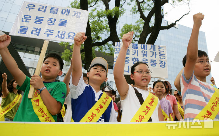 [서울=뉴시스] 2007년 8월 3일 오전 서울 배재정동빌딩 앞에서 열린 덕수초등학교 운동장 사수 집회에서 학부모들과 어린이들이 피켓을 들고 시위하고 있다.