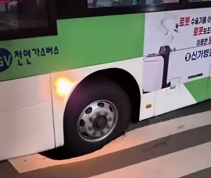 [광주=뉴시스] 3일 오후 8시55분께 광주 광산구 우산동 한 도로에서 주행 중이던 시내버스 앞바퀴가 땅꺼짐 현상(싱크홀)이 발생한 도로에 빠졌다. (사진 = SNS 갈무리) photo@newsis.com *재판매 및 DB 금지