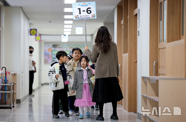 [대구=뉴시스] 이무열 기자 = 3일 대구 달서구 대구장동초등학교에서 입학식을 마친 신입생 어린이들이 담임선생님과 교실로 향하고 있다. 2026.03.03. lmy@newsis.com