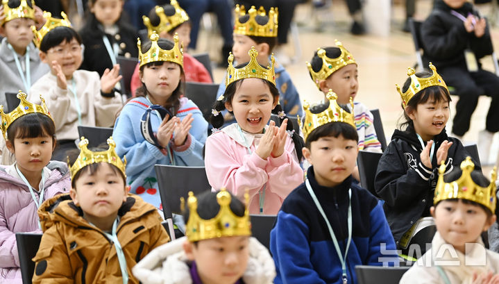 [수원=뉴시스] 김종택 기자 = 3일 경기 수원시 대평초등학교에서 열린 입학식에서 왕관을 쓴 신입생 어린이들이 공연을 보며 박수를 치고 있다. 2026.03.03. jtk@newsis.com