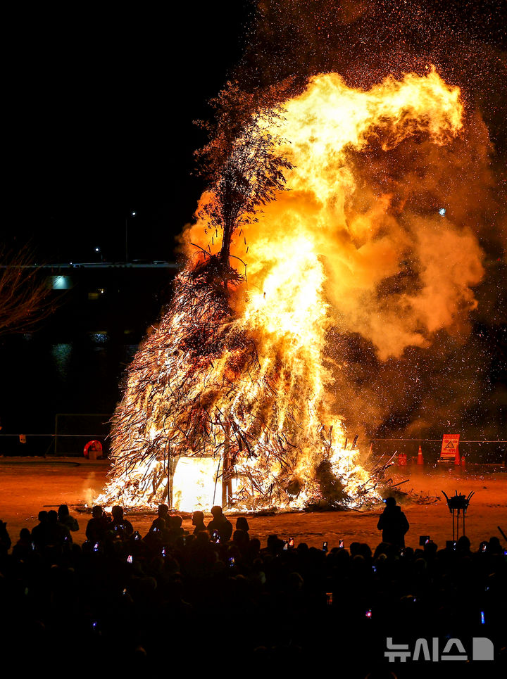 [대구=뉴시스] 이무열 기자 = 정월대보름인 3일 오후 대구 북구 산격야영장에서 열린 ‘2026 금호강 정월대보름 축제’에서 시민들이 활활 타오르는 달집을 바라보고 있다. 2026.03.03. lmy@newsis.com