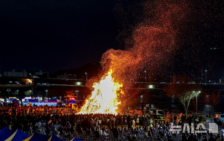 [대구=뉴시스] 이무열 기자 = 정월대보름인 3일 오후 대구 북구 산격야영장에서 열린 ‘2026 금호강 정월대보름 축제’에서 시민들이 활활 타오르는 달집을 바라보고 있다. 2026.03.03. lmy@newsis.com
