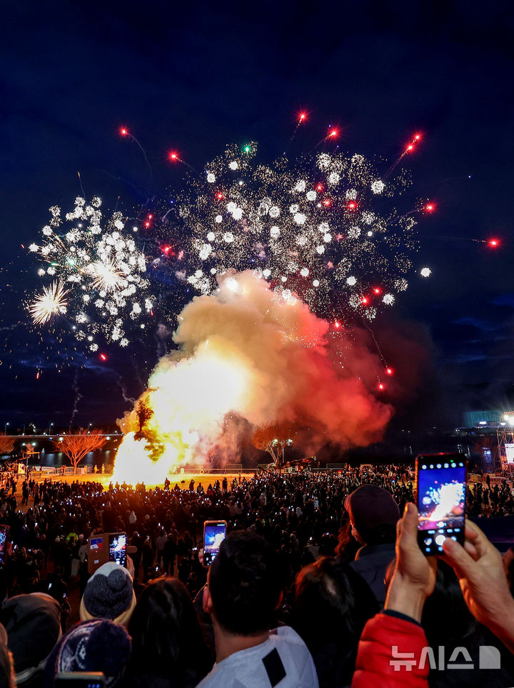 [대구=뉴시스] 이무열 기자 = 정월대보름인 3일 오후 대구 북구 산격야영장에서 열린 ‘2026 금호강 정월대보름 축제’에서 시민들이 활활 타오르는 달집을 바라보고 있다. 2026.03.03. lmy@newsis.com